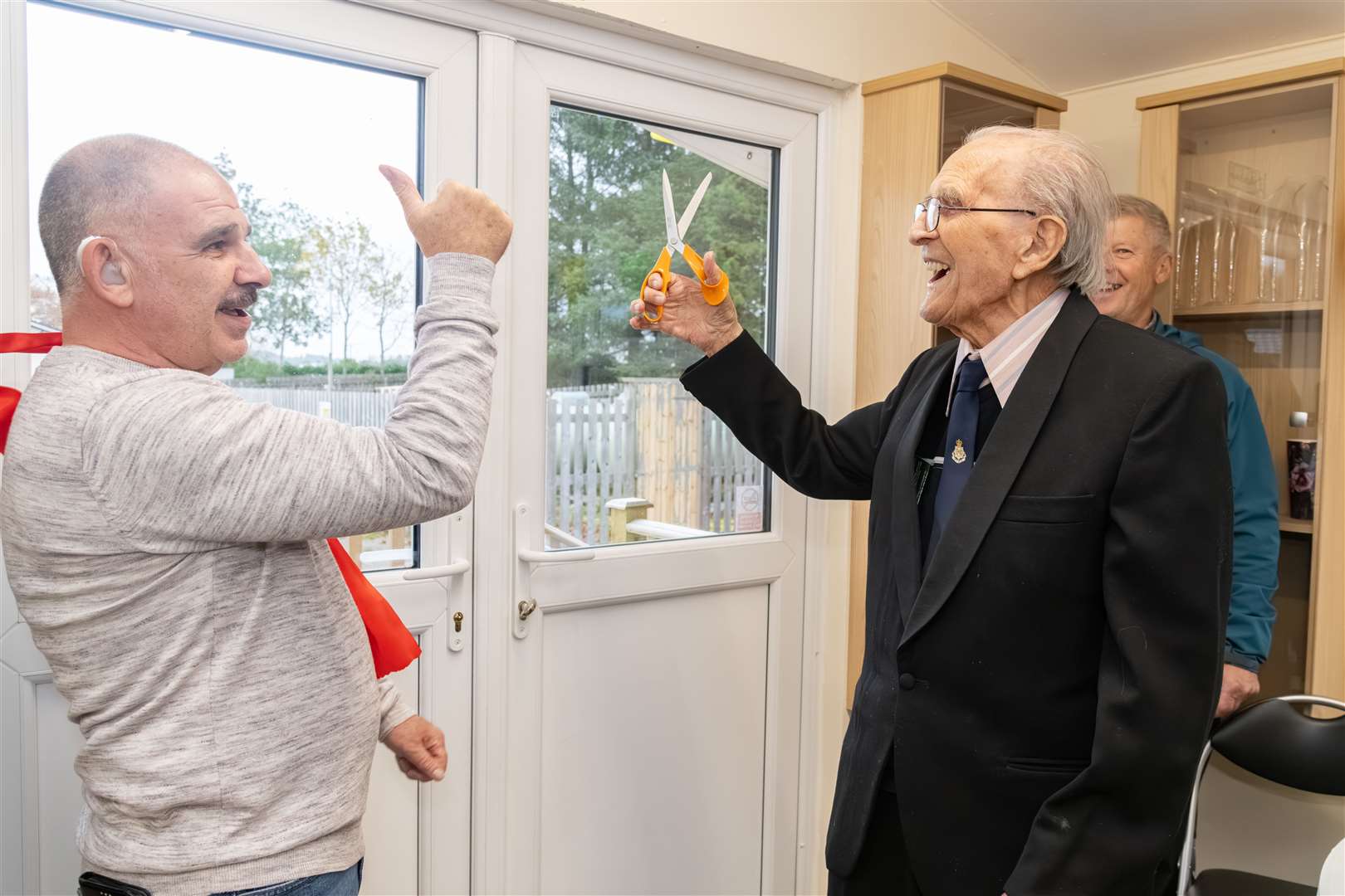 Bill Gray (left) gives the thumbs up as Walter Childs cuts the ribbon to officially open the new community hub.