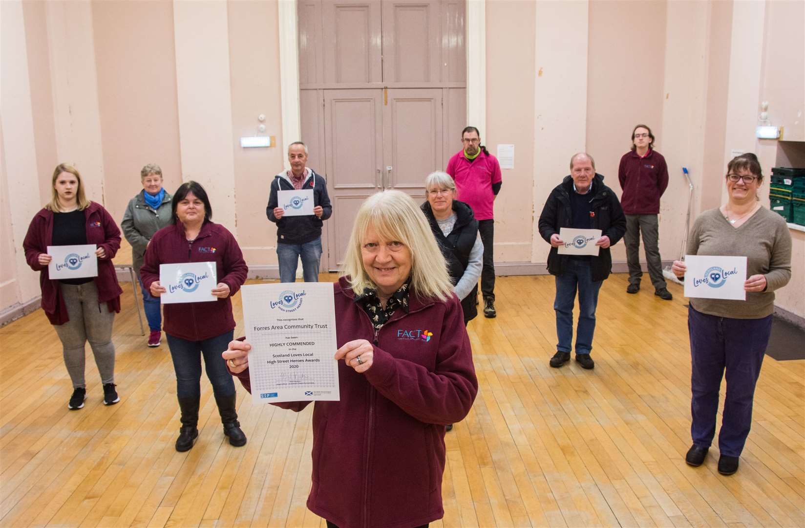 Forres Area Community Trust at the town hall with their certificates.