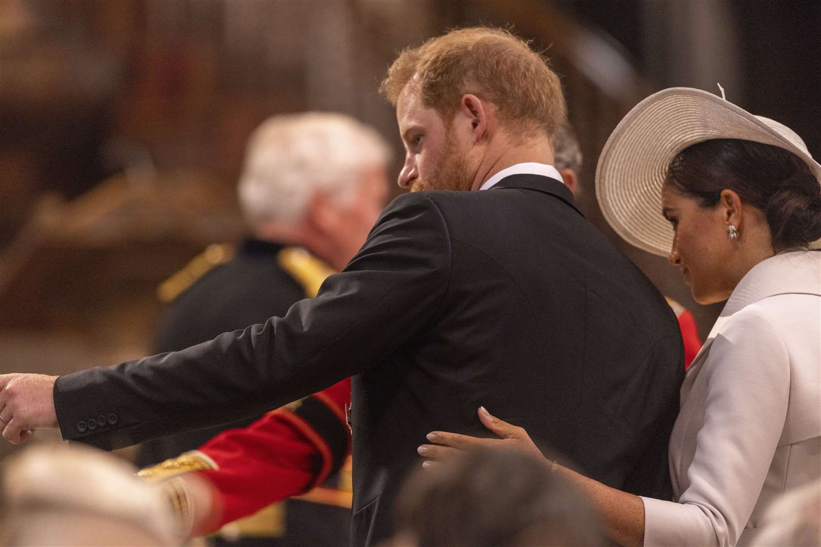 Meghan with her hand on Harry’s back (Ian Vogler/Daily Mirror/PA)