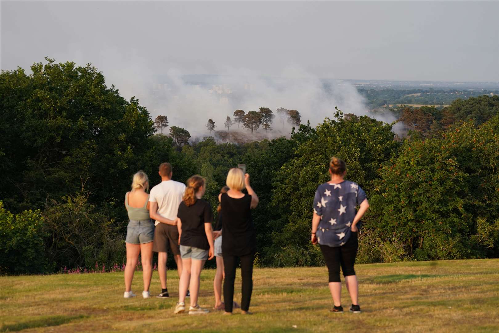 People watch a large wildfire that broke out in woodland at Lickey Hills Country Park on the edge of Birmingham (Jacob King/PA)