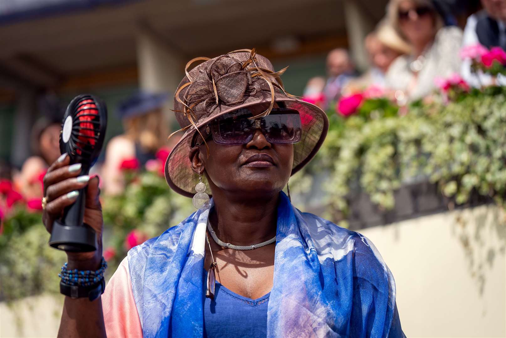 A racegoer uses a fan to stay cool during day three of Royal Ascot at Ascot Racecourse (Aaron Chown/PA)