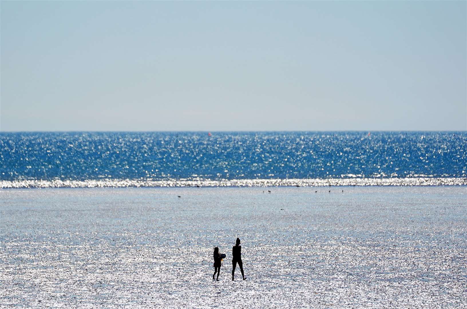 People walk on Dollymount Strand in Dublin as some parts of the country reached 33C (Brian Lawless/PA)