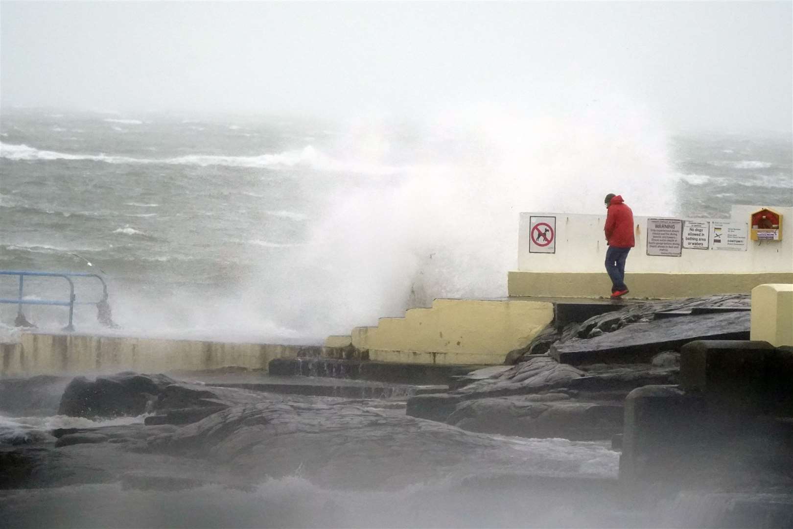 A person looking at high waves in Salthill, Galway, during Storm Isha (Niall Carson/PA)