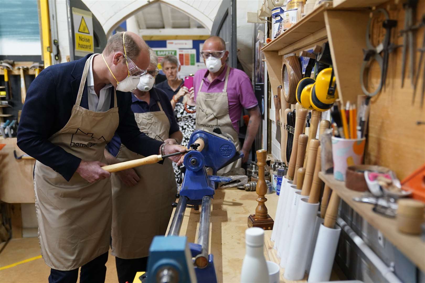 The Prince of Wales used a lathe during a visit to Faithworks’ carpentry workshop (Andrew Matthews/PA)