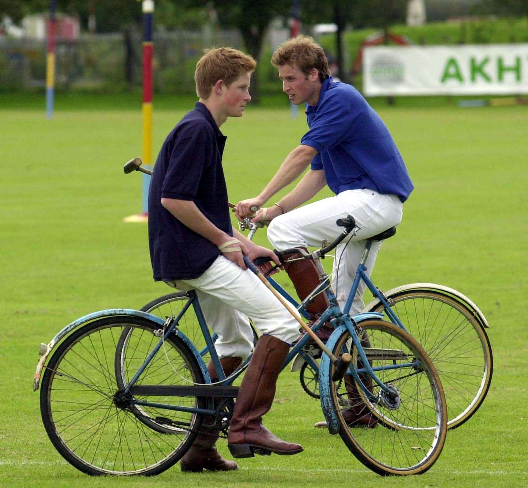 Prince Harry and Prince William take a break while playing in the bicycle part of the Jockeys v Eventers charity polo match in 2002 (Barry Batchelor/PA)