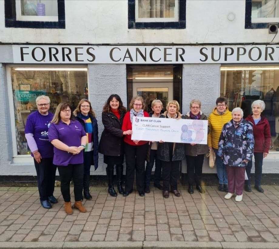 Volunteers from the shop handing over the cheque to Clan Cancer Support.