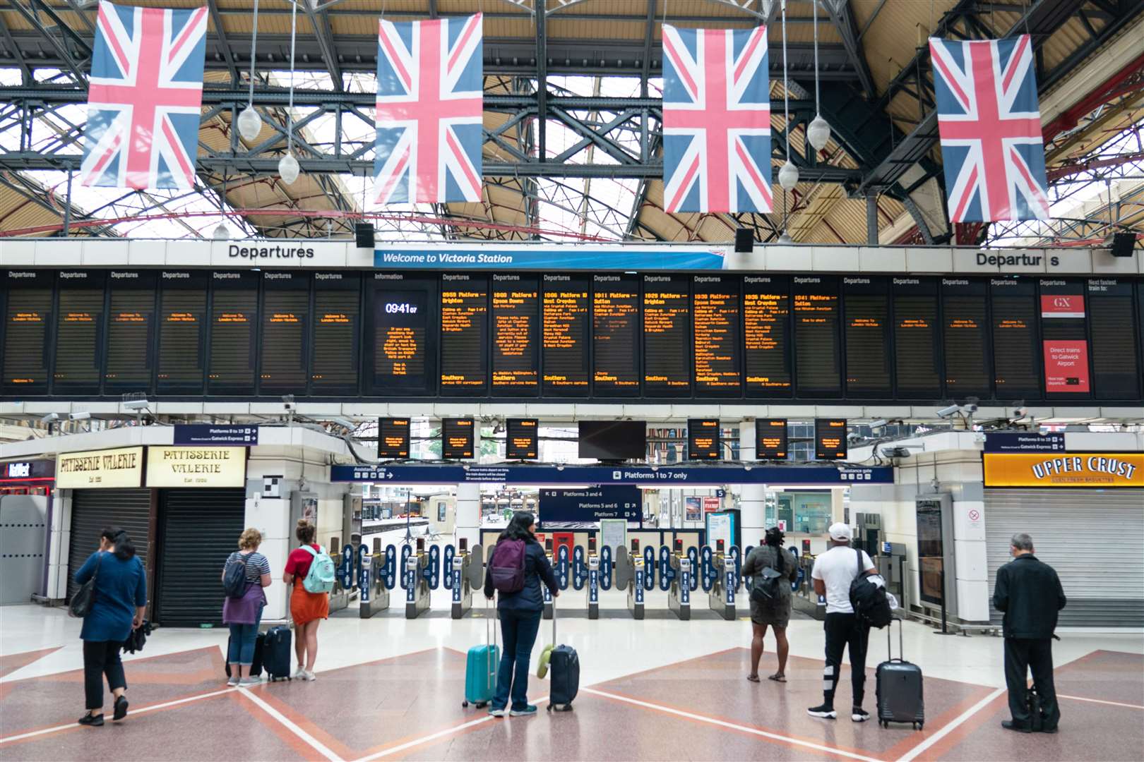 Passengers view departure boards at Victoria station in London (Dominic Lipinski/PA)