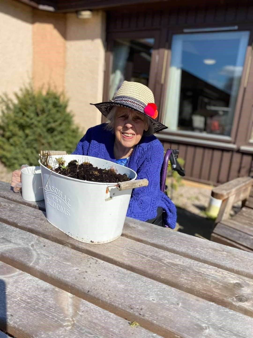 Cally Miller enjoying a cup of tea after sowing seeds in her planter.