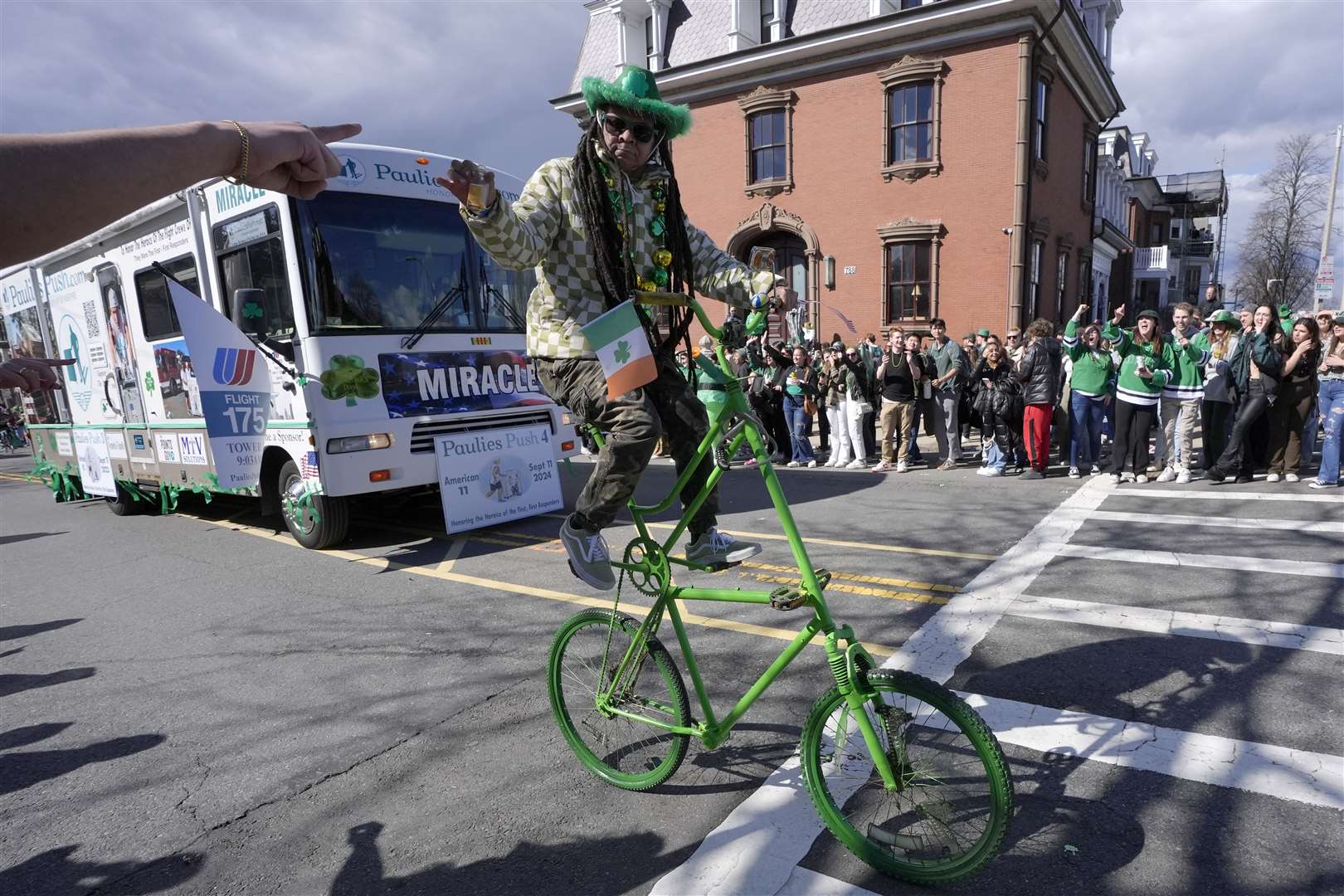 A man on a bicycle greets spectators during the St Patrick’s Day parade in the US city of Boston (Steven Senne/AP)