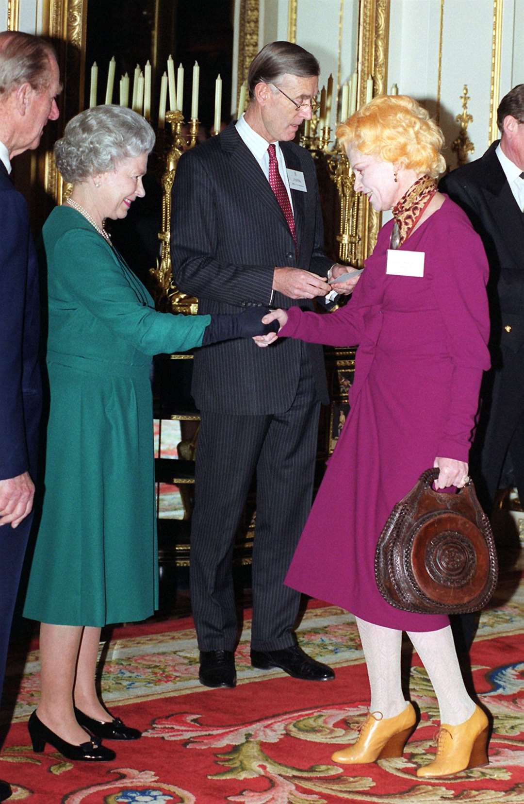 The Queen shakes hands with the designer in 1999 (Fiona Hanson/PA)