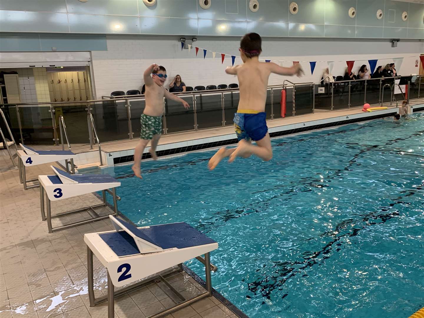 Theodore Stephen (P3) jumping into Forres Swimming pool with Jacob Mackintosh (P4) during a SwimABLE session. Photo take pre-covid-19 restrictions.