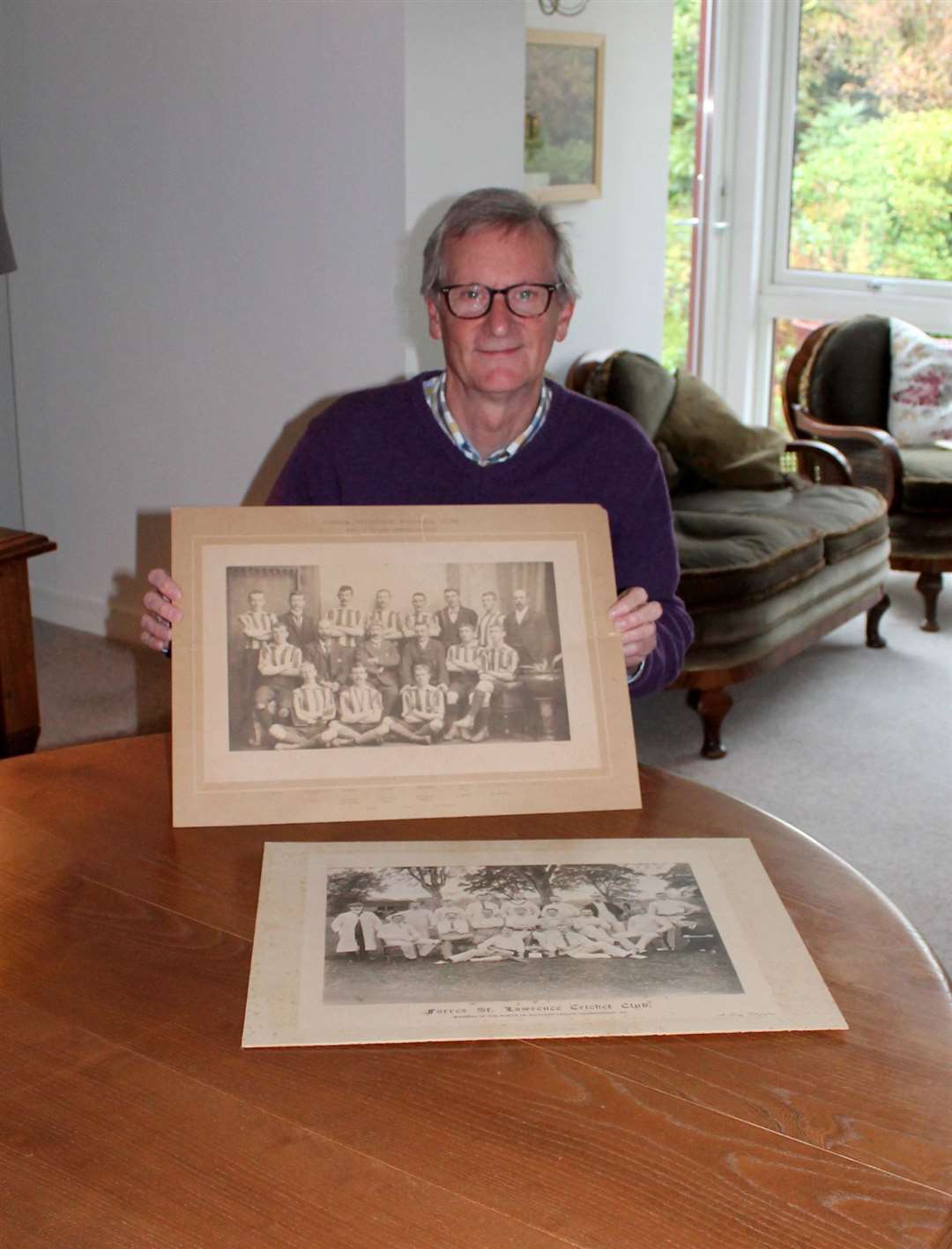 Tom Duff with two photographs which were donated to Forres Heritage Trust.