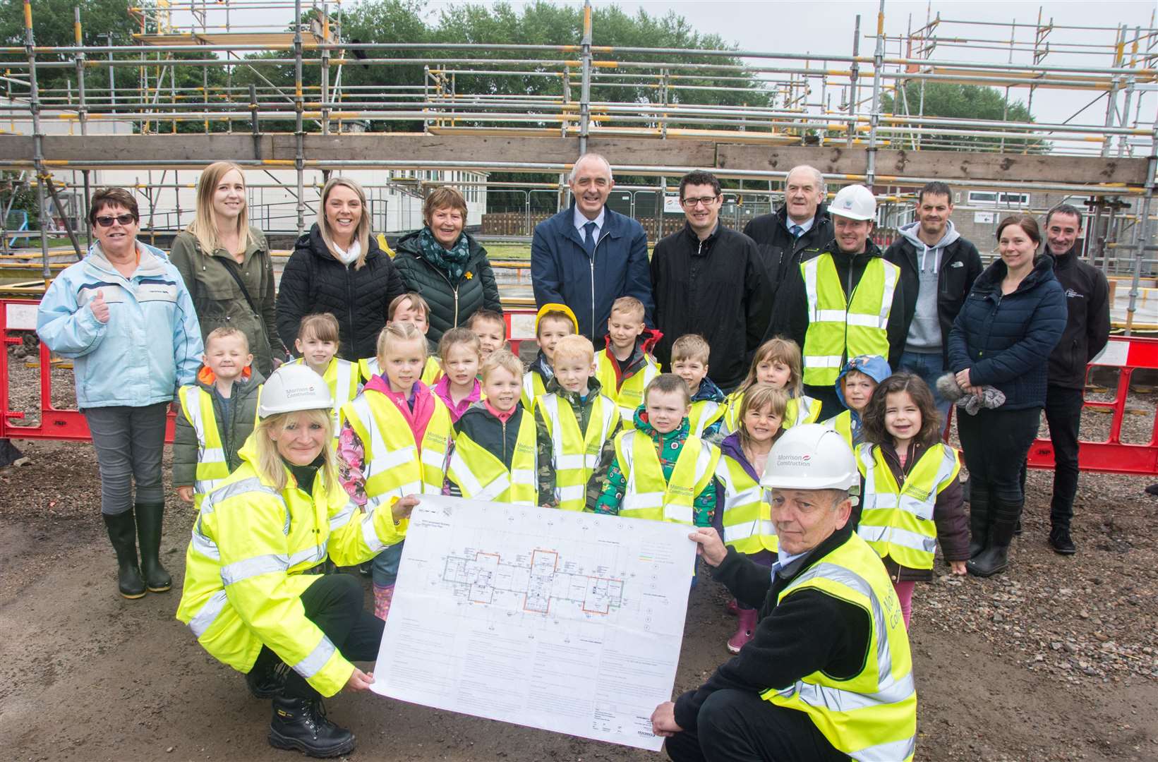 Sally Cooper (corporate social response manager) and Paul Skilling (site manager) hold up site plans in front of kids. Forres Councillors George Alexander, Lorna Creswell and Aaron McLean join head teacher Mr Leslie Tulloch in the back row.