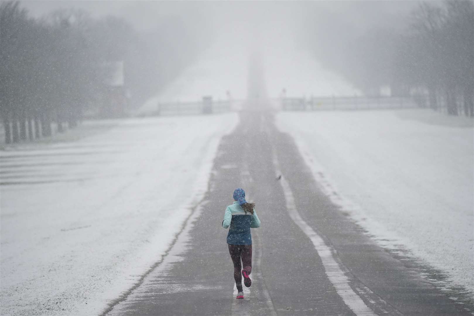 A jogger takes a run in the snow at the Long Walk near Windsor Castle on Wednesday (Yui Mok/PA)