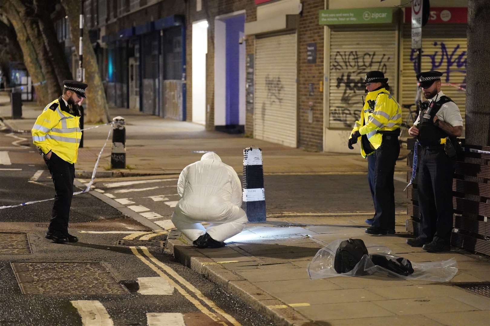 Police and forensics officers working at the scene (James Manning/PA)