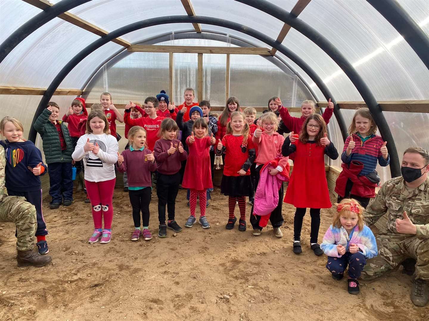 Thumbs up from the children in their new polytunnel.
