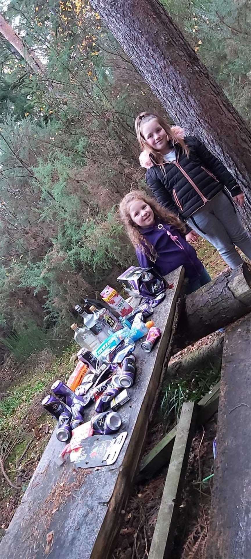 Lexi and Lola at the Sanquhar hut picnic table littered with empty booze bottles and cans.