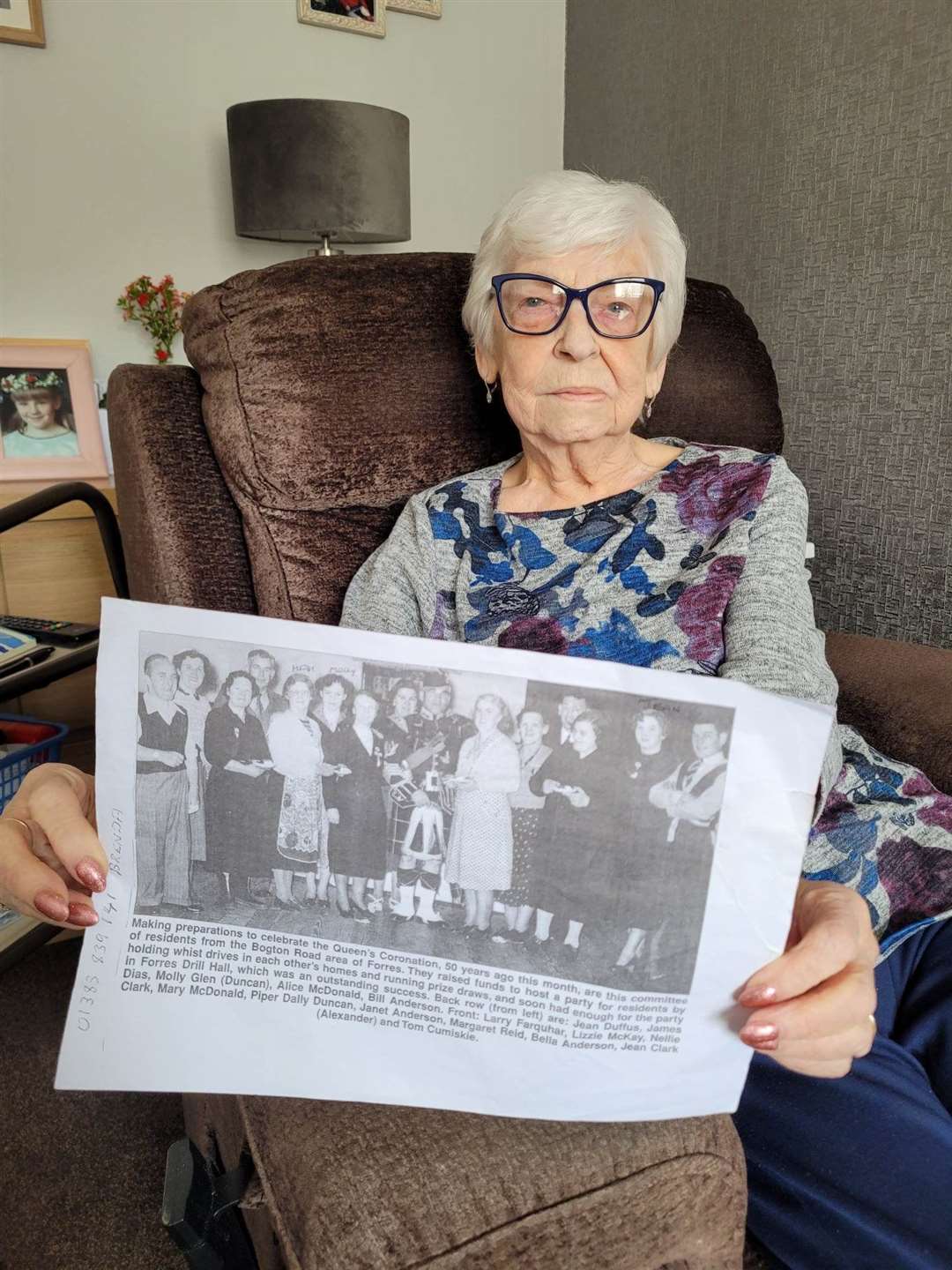 Jean at home with her copy of a picture of some of the Shanghai-ers at their coronation party in 1953.