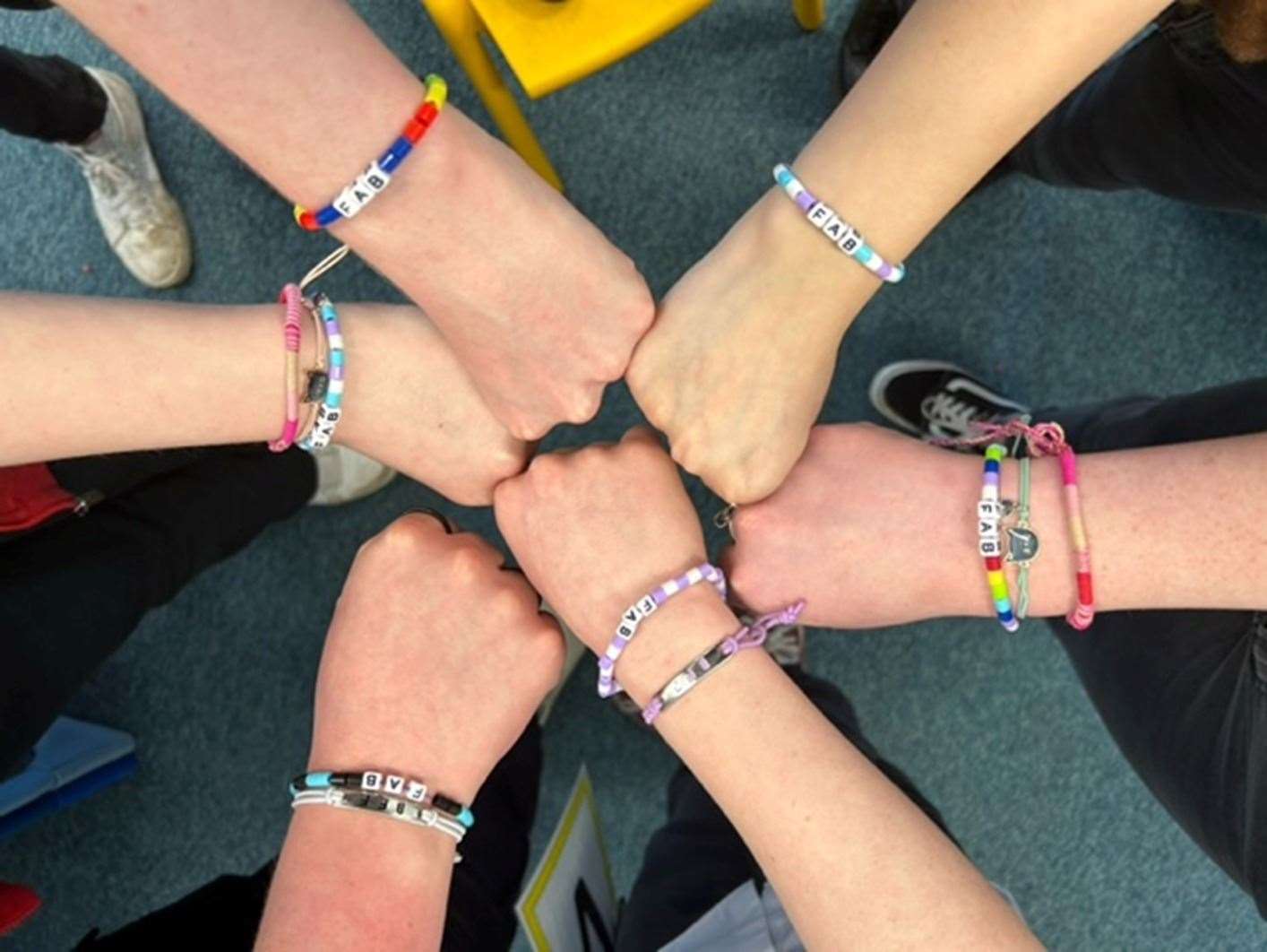 Pupils showing off FAB bracelets created during PSE classes.