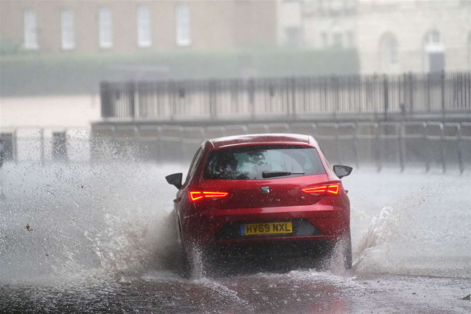 A car drives through flood water in Horse Guards Road in central London (Victoria Jones/PA)