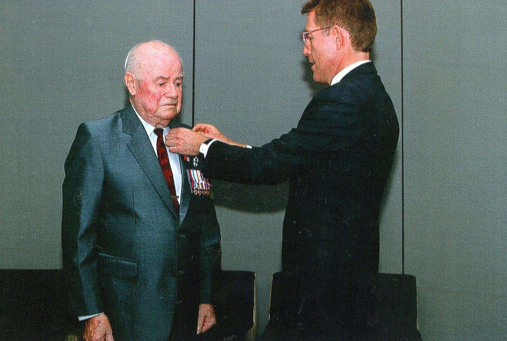 Mr Nicolas Crozier (right) the French Consul-General from Sydney bestows France’s highest honour on Alex.
