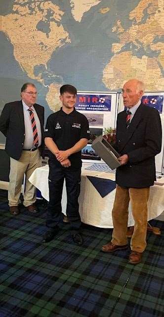 MIRO's youngest crew member, Jamie Paterson, presenting a bottle of whisky to Roddy Stewart.