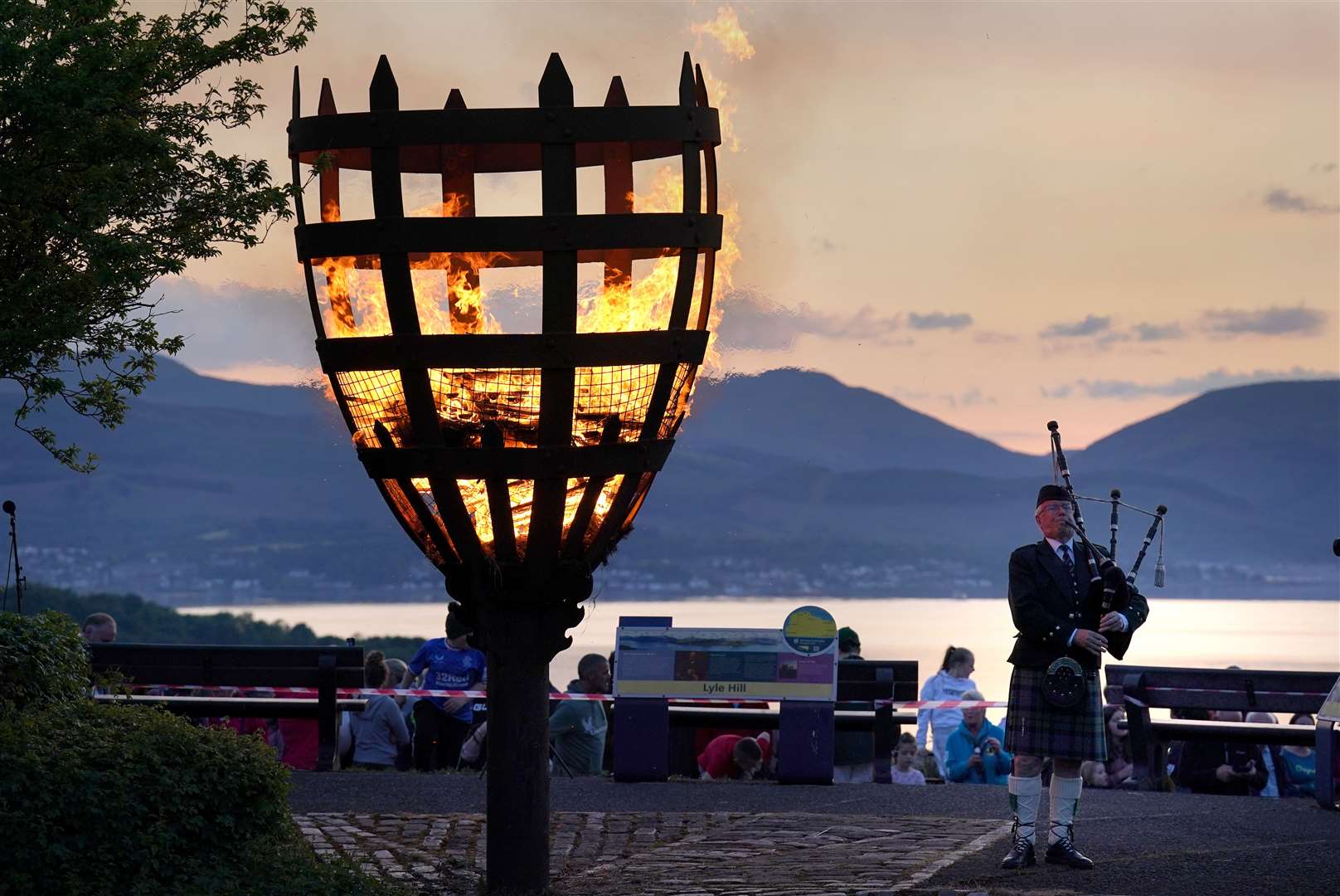 A Platinum Jubilee beacon is lit on Lyle Hill, Greenock as Piper Major John MacLeod of Inverclyde Pipes and Drums plays (Andrew Milligan/PA)