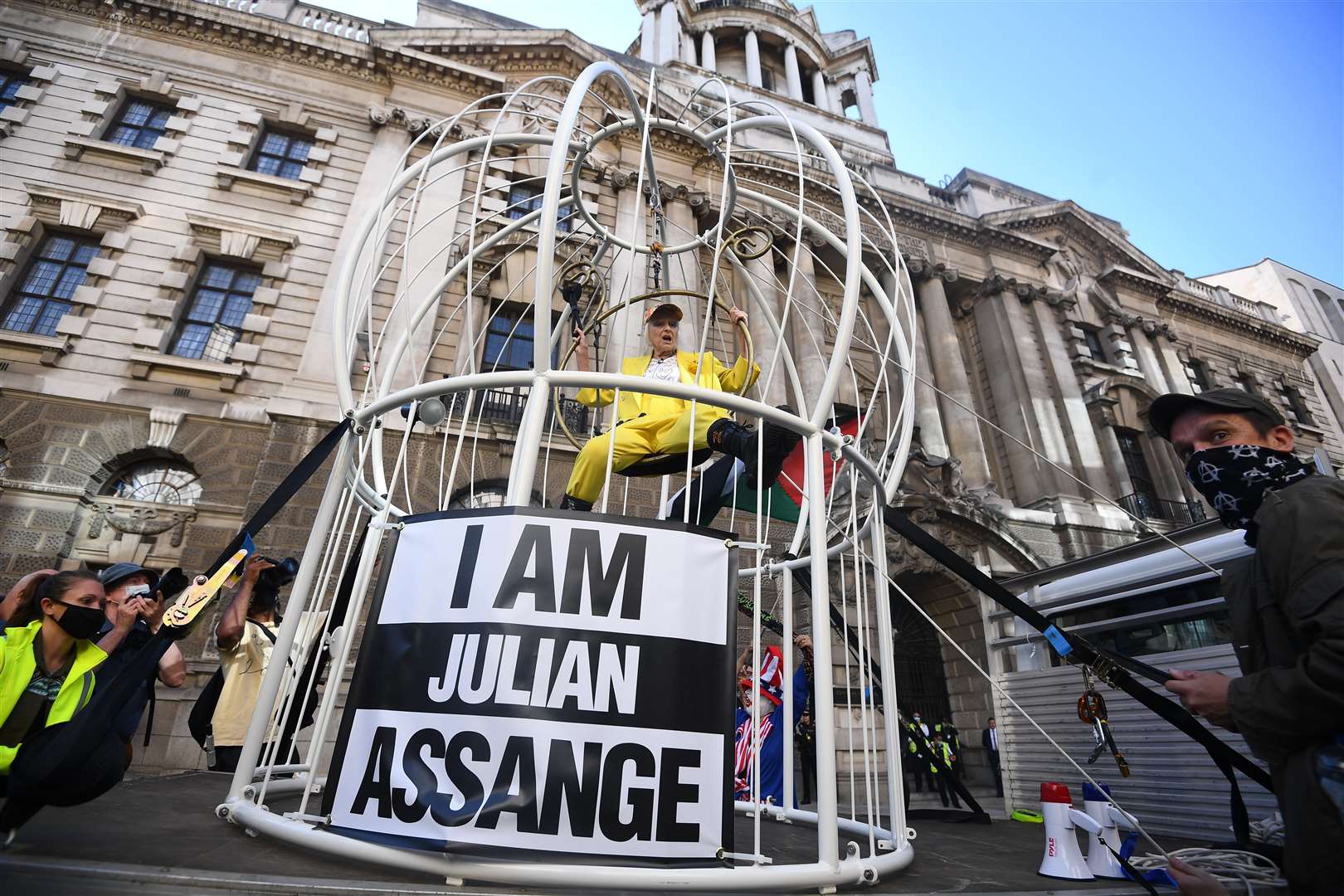 Dame Vivienne Westwood is suspended in a 10ft high bird cage outside the Old Bailey in London to protest against the extradition of Julian Assange (Victoria Jones/PA)