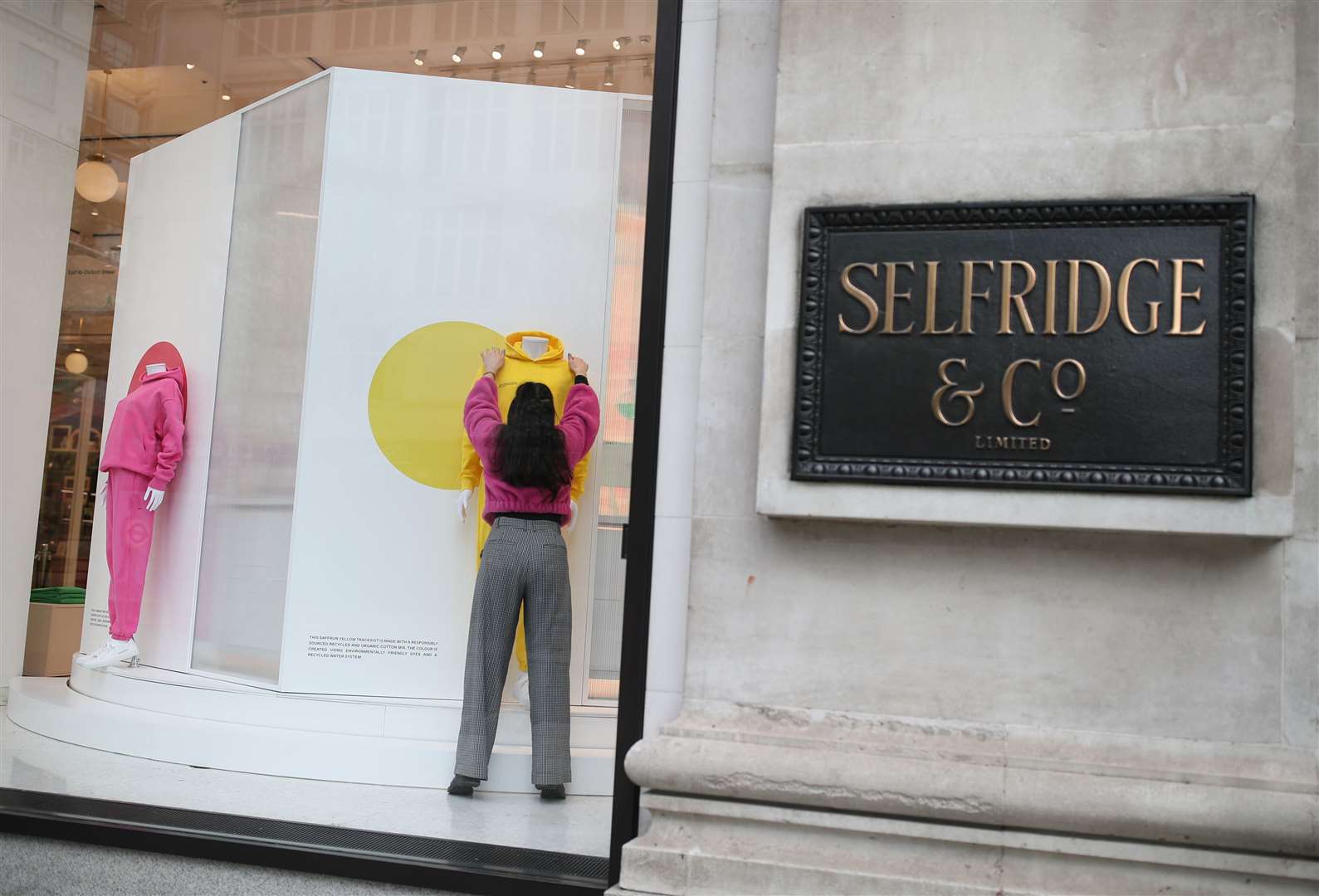 Visual merchandisers and windows team members put the finishing to a display at Selfridges’ flagship store in London before it reopened in April (Yui Mok/PA)