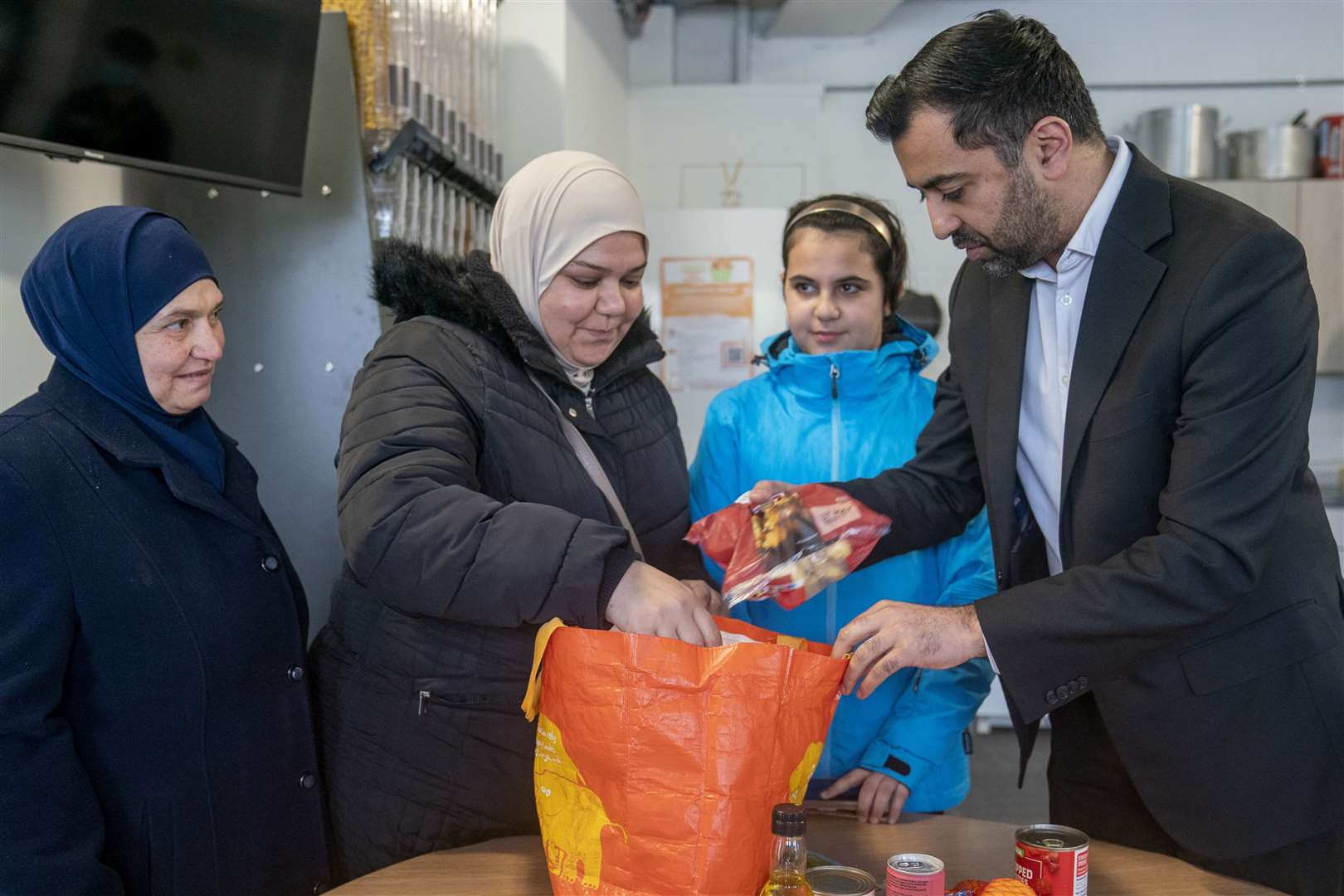 First Minister of Scotland Humza Yousaf meets members of the local community during a visit to the Whitfield Community Larder in Dundee (Jane Barlow/PA)