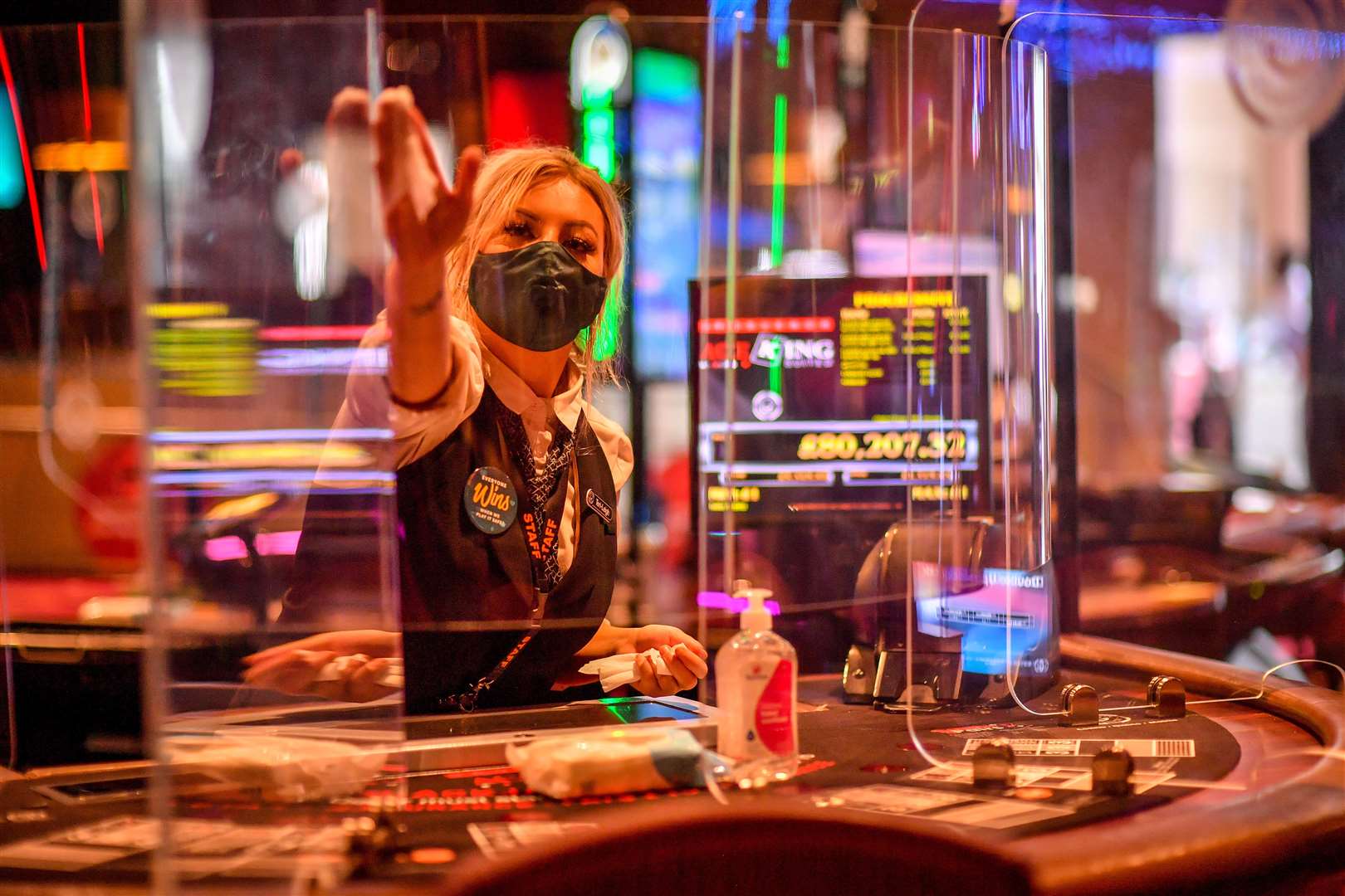 Staff clean clear plastic dividing screens between players and dealers at the Grosvenor Casino in Cardiff (Ben Birchall/PA)