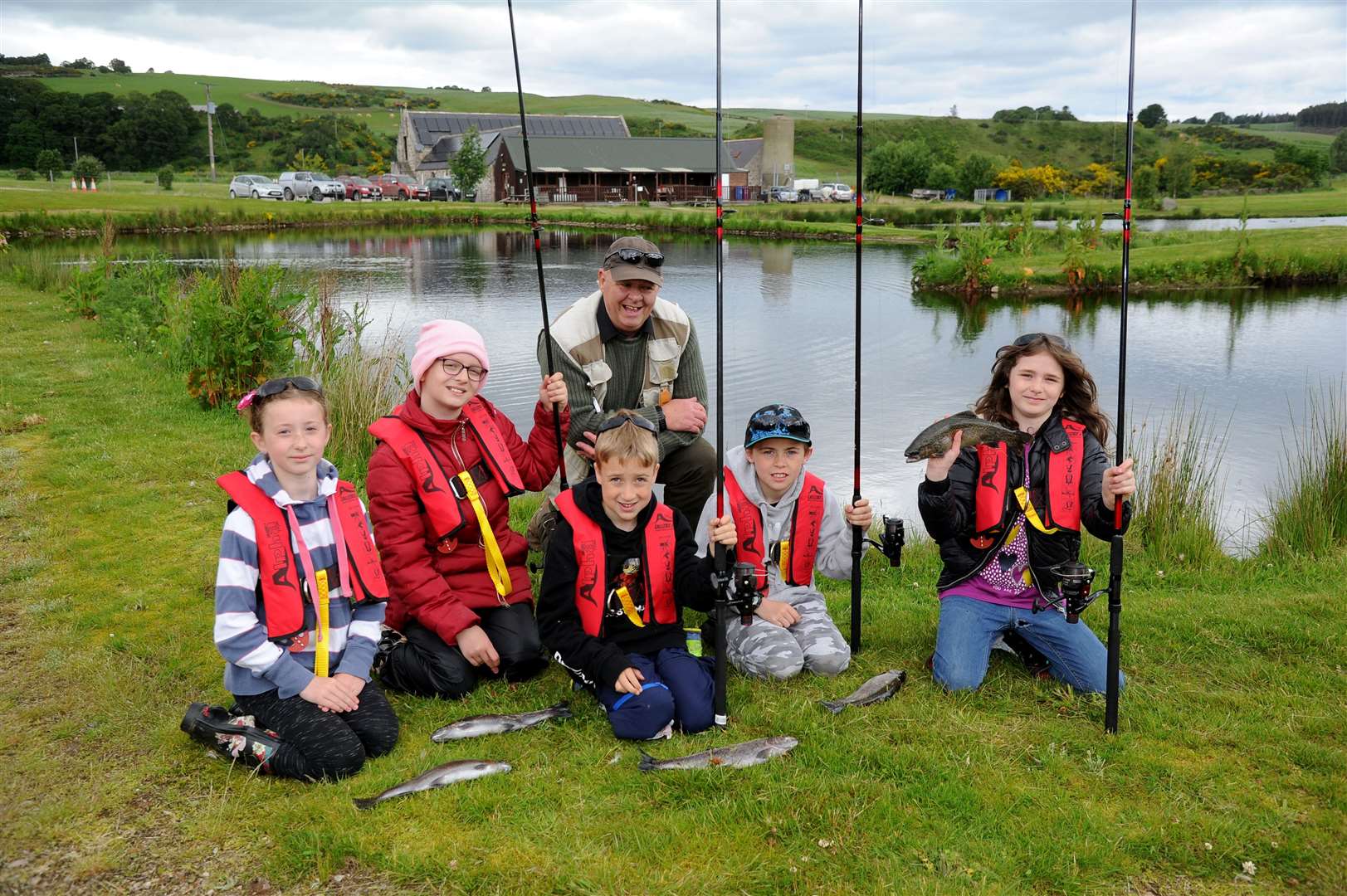 Picture: Eric Cormack. Image No.044223.PIlmuir Pupils Visit Kellas Trout Fishery. .L-R Holly Addy, Erin Kennedy, Murray Williams, Sasha Hamilton And Forres Angling Club Member Steve Pannell..See Gary.