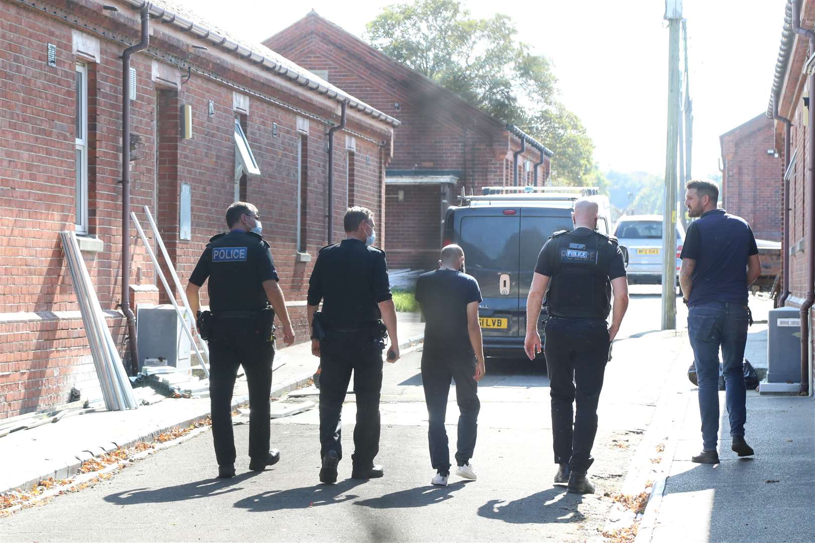 Police officers are escorted around Napier Barracks (Gareth Fuller/PA)