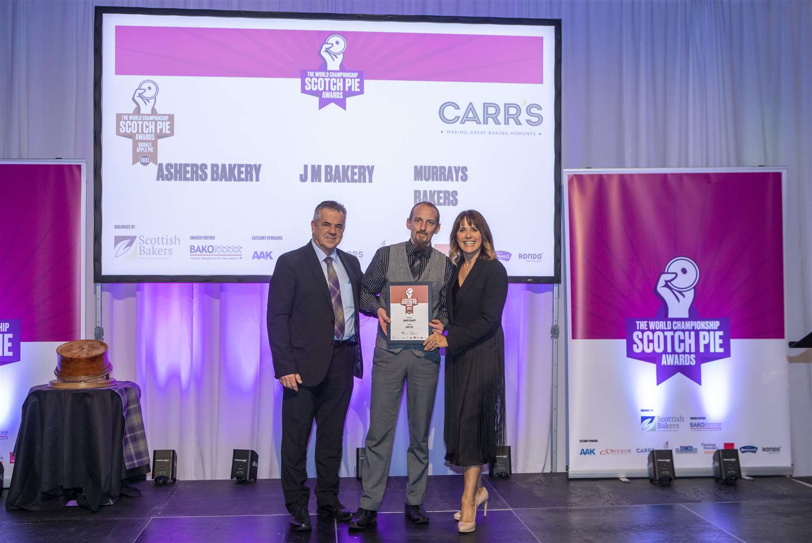 Carr's Flour sales and marketing director Allan Burns, Ashers bakery manager Garry Mann and event presenter Carol Smilie at the World Championship Scotch Pie Awards 2023.