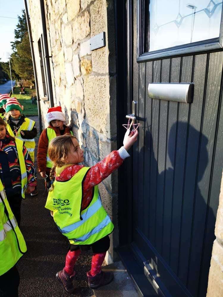 Isla hanging her gift on one of the village doors.