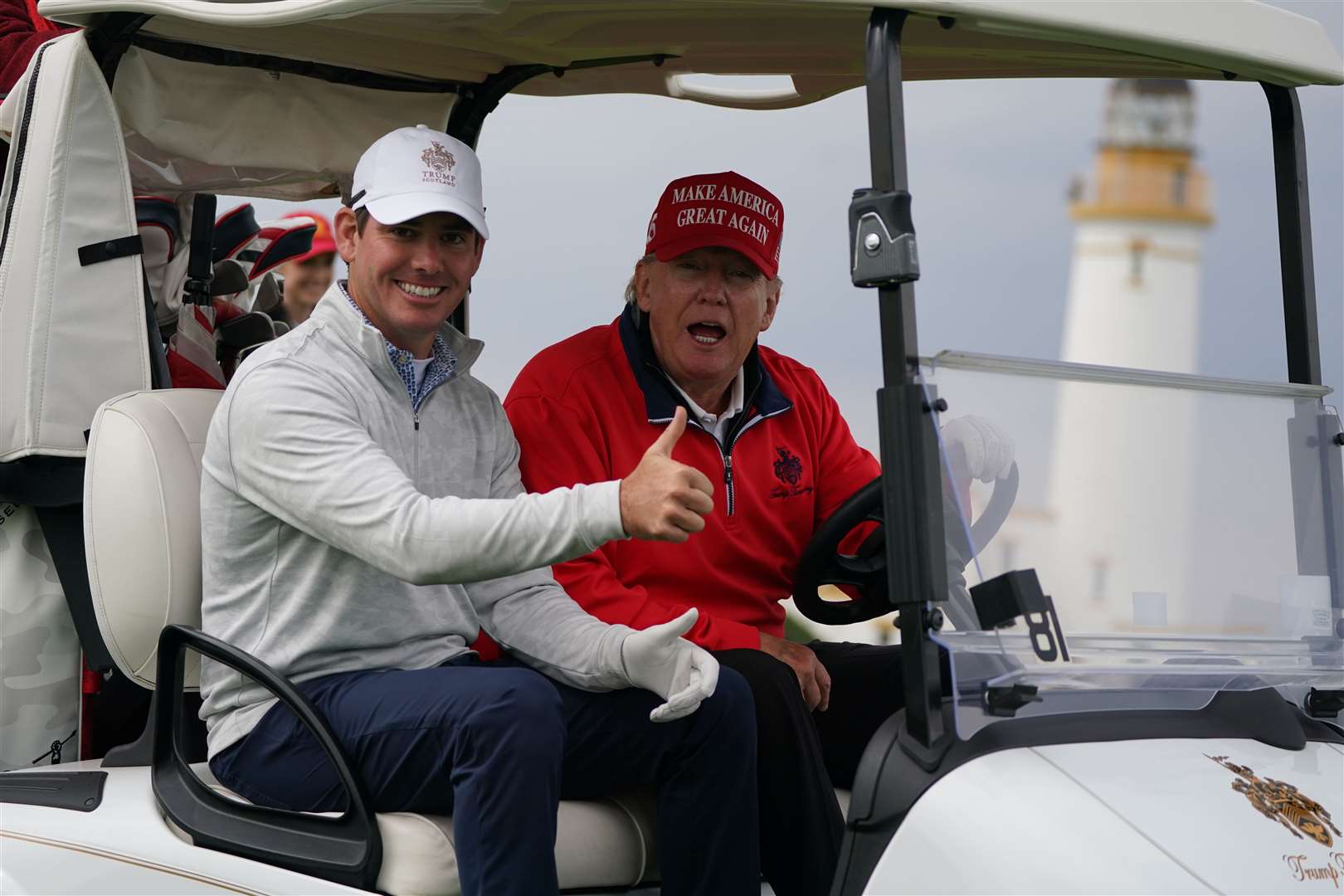 Donald Trump drives a golf buggy on the Turnberry course (Andrew Milligan/PA)