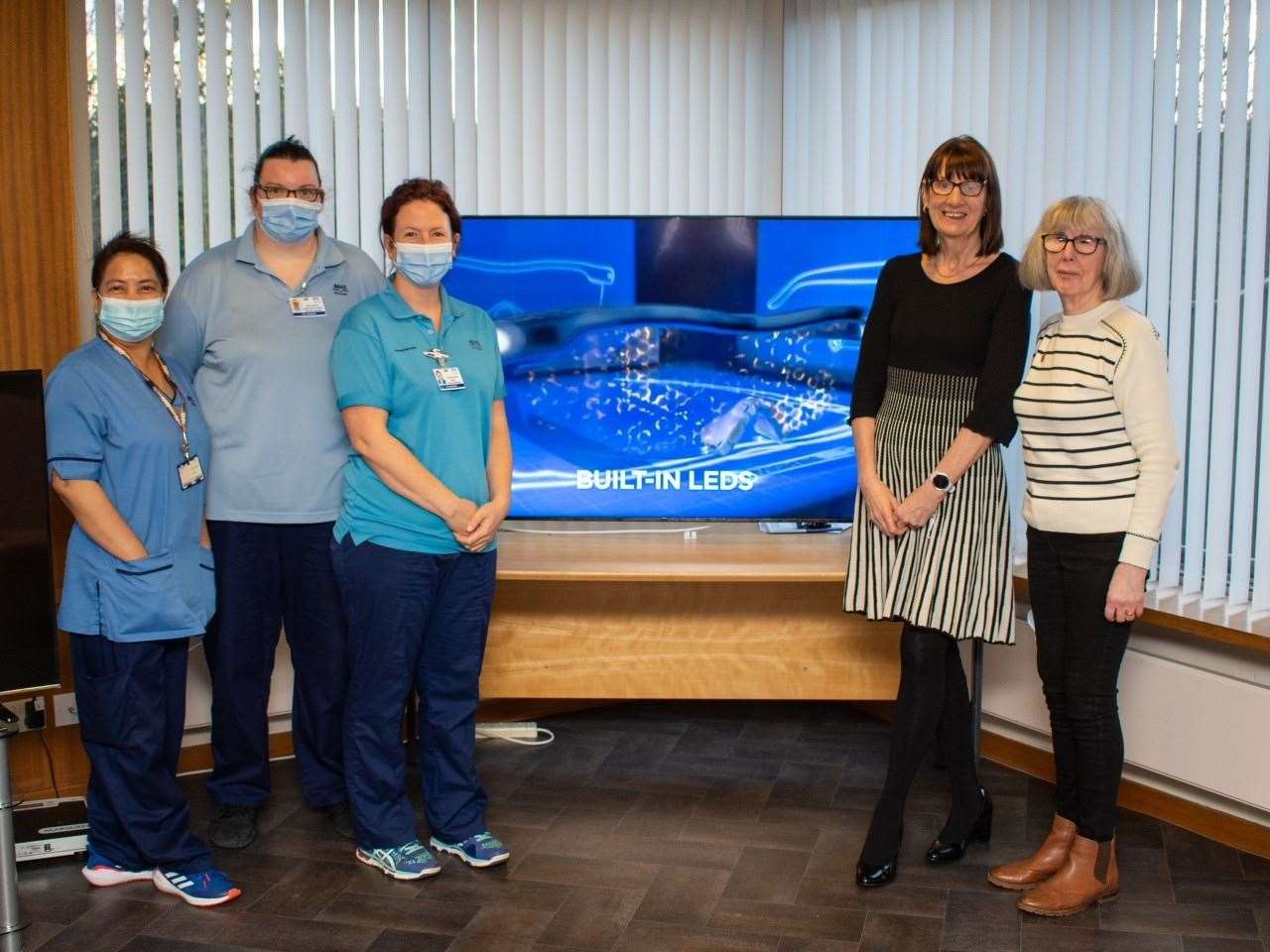 Woodend Hospital staff Nurse Esme Reys, senior healthcare support worker Nicki Mutch, senior physiotherapist Catriona Reid, and George’s sisters Ishbel Munro and Audrey Stewart with the flatscreen TV from the donation.