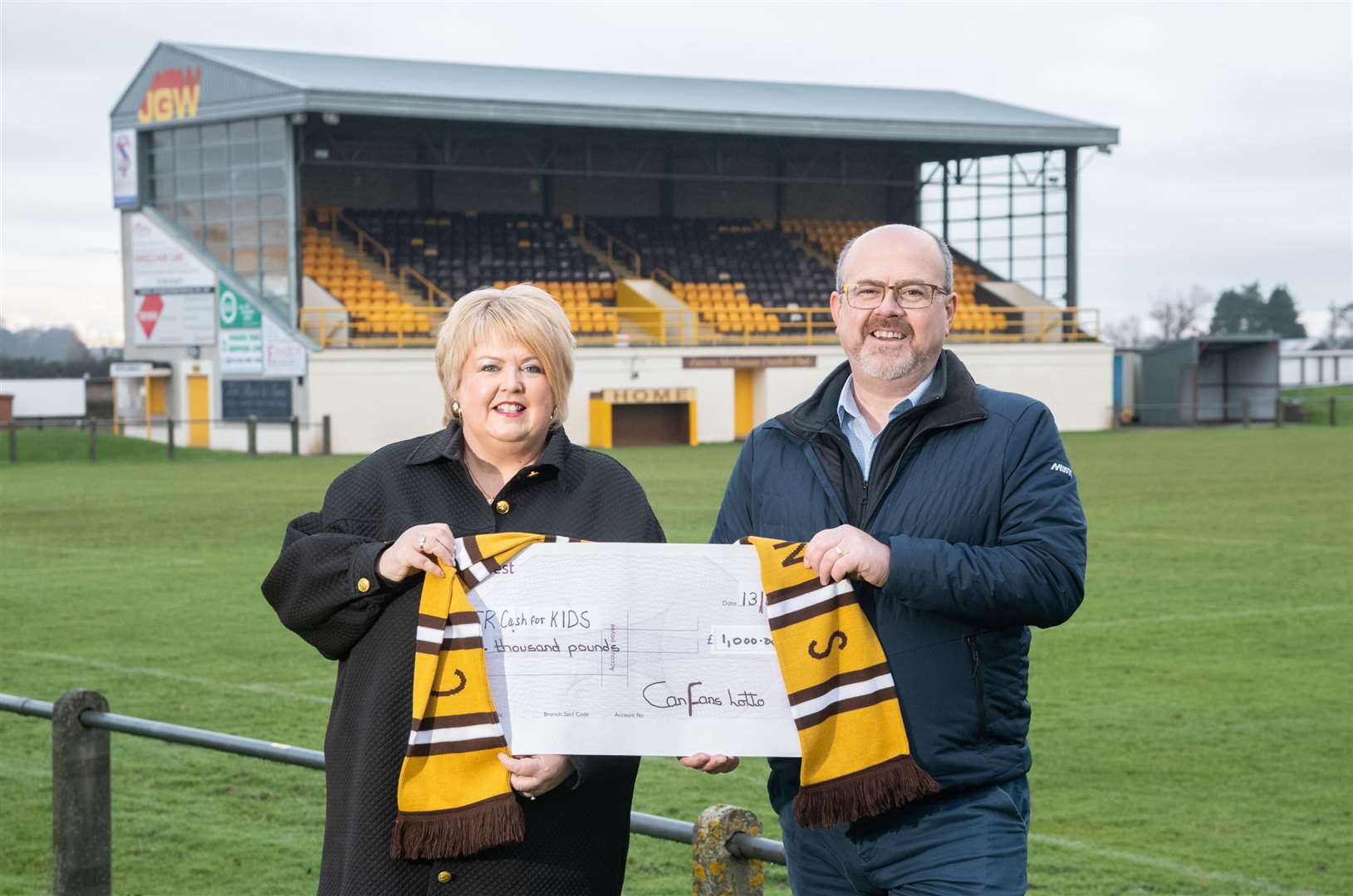 Pamela Brown accepts a cheque for £1000 for Cash for Kids from Graham Alexander of the club’s Cans Fans Lotto. Picture: Daniel Forsyth