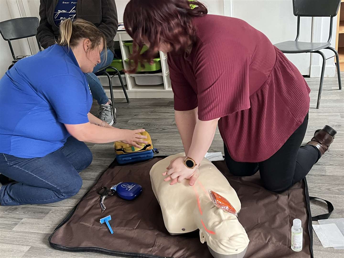 Jennifer Smith fromthe club (left) and parent Elysia-Rose Barksby pretend they have found someone who is not breathing. They assessed the situation for dangers before Elysia-Rose started CPR while Jennifer prepared to use the defibrillator to try and resuscitate the person by shocking their heart.