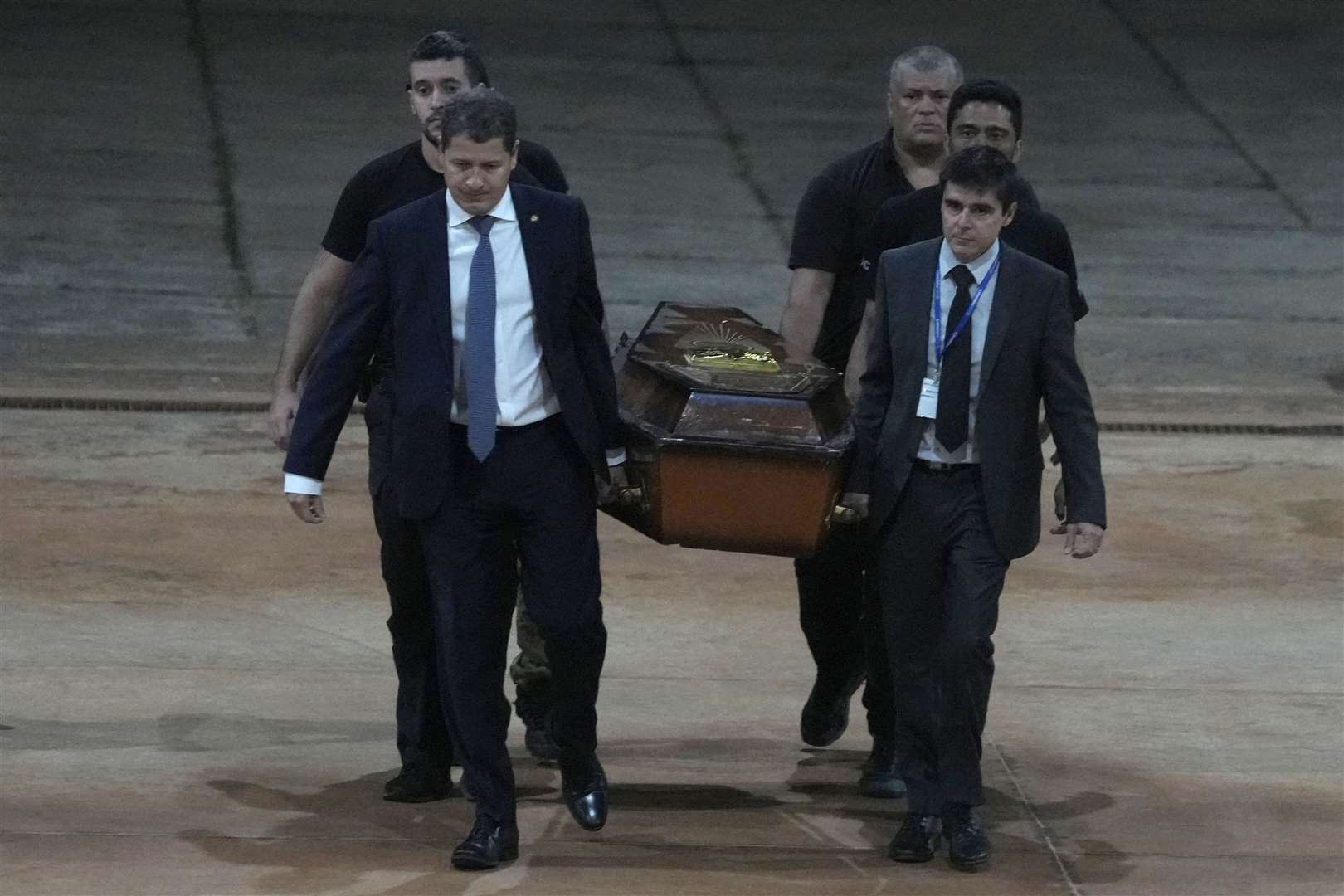 Federal police officers arrive with recovered human remains at the federal police hangar in Brasília on Thursday night (Eraldo Peres/AP)