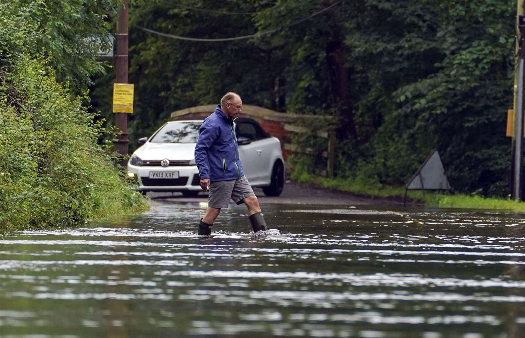 A man wades through a flooded road near Swallowfield, Berkshire (Steve Parsons/PA)