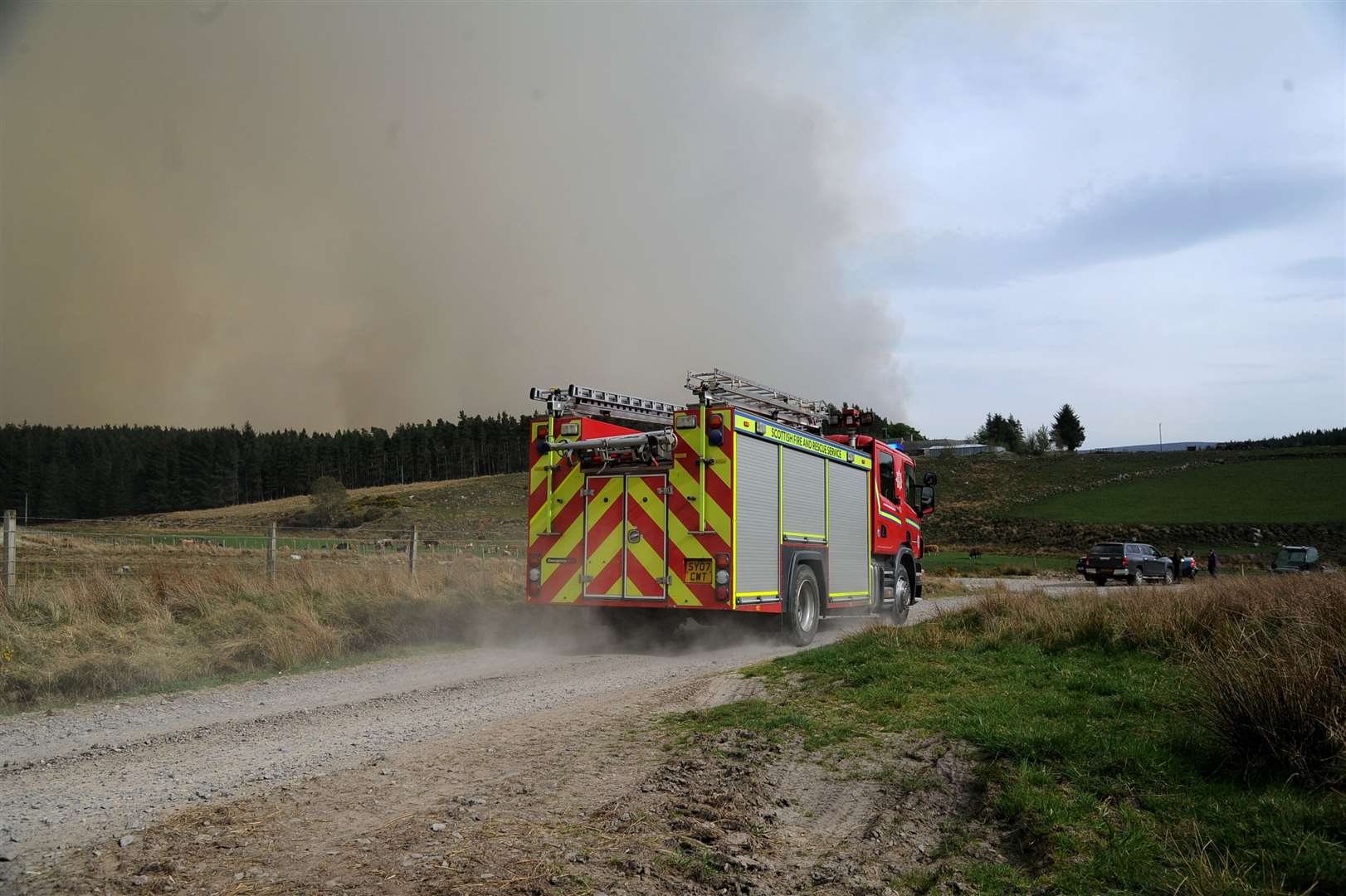 The Fire Which Started At Pauls Hill Wind Farm Reaches Dumphail South Of Forres. A Fire Tender Speeds Towards The Smoke.Picture: Eric Cormack. Image No.043809.