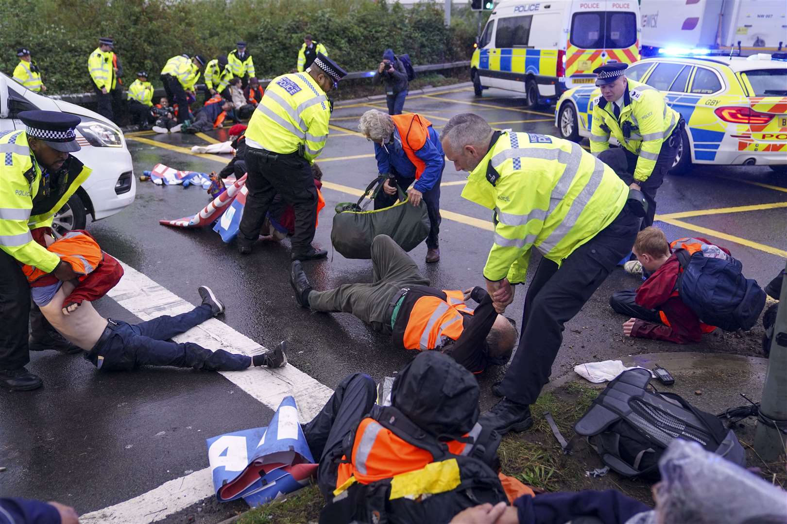 Police officers detain a protester from Insulate Britain near the M25 last month (PA)