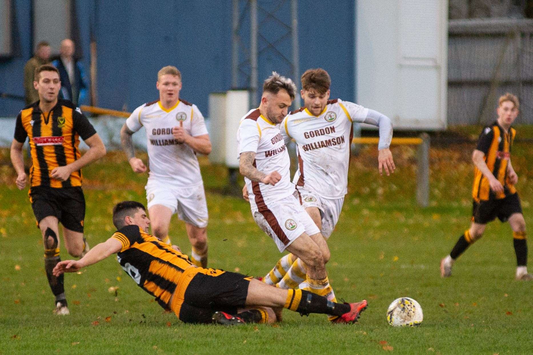 Huntly captain Glenn Murison goes in for a challenge on Forres' Paul Brindle. Picture: Daniel Forsyth..