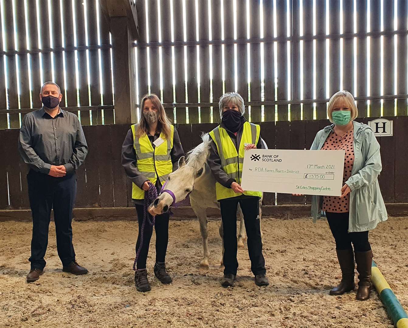 St Giles manager Stephen Young (left) and colleague Angie Chisholm (right) presenting the cheque to RDA trustees Emma Gregg and Julie Campbell.