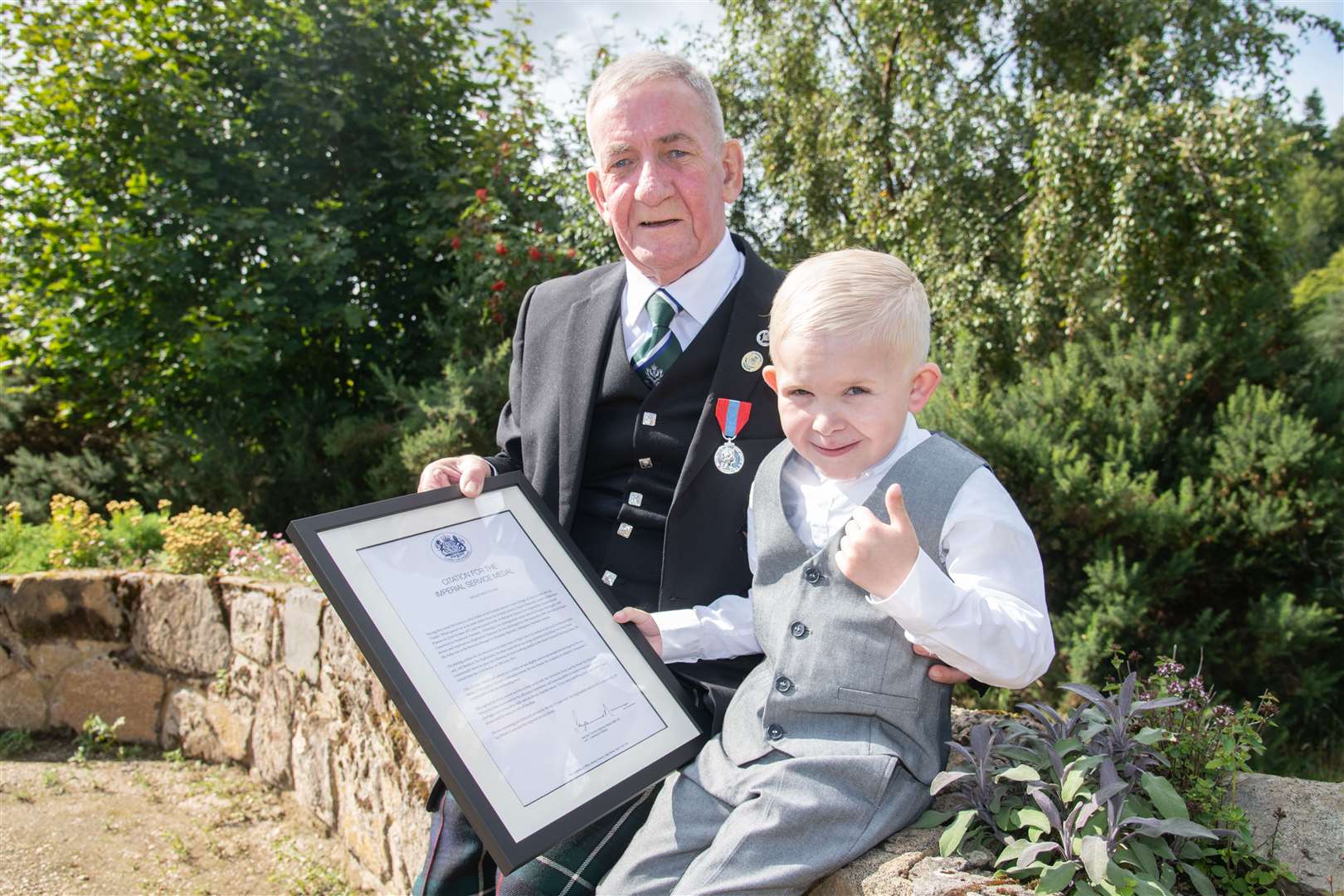 Elgin's Ian 'Chalky' Whyte with his Imperial Service Medal and his grandson. Picture: Daniel Forsyth