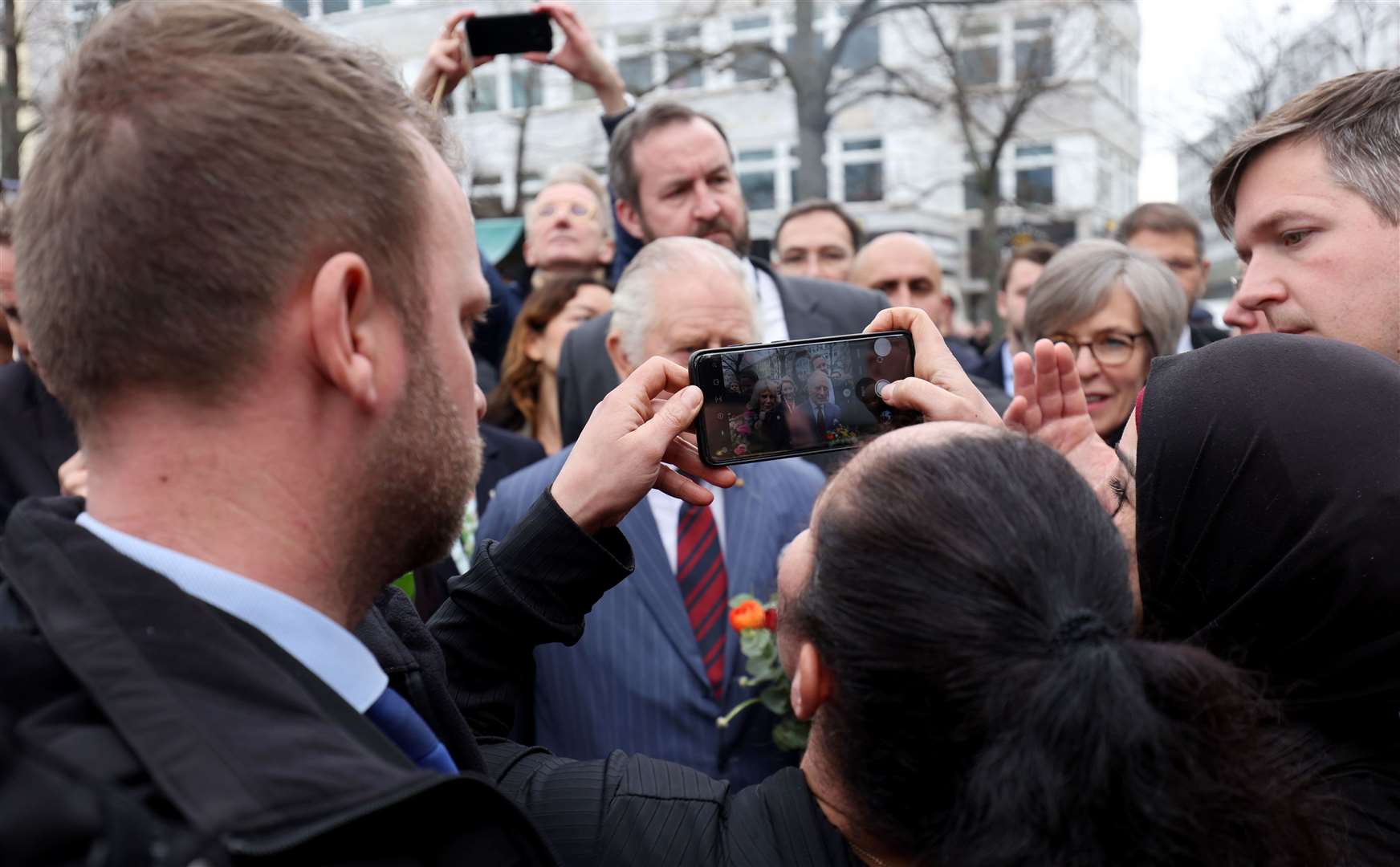 A woman uses her phone to take a picture of Charles (Adrian Dennis/PA)