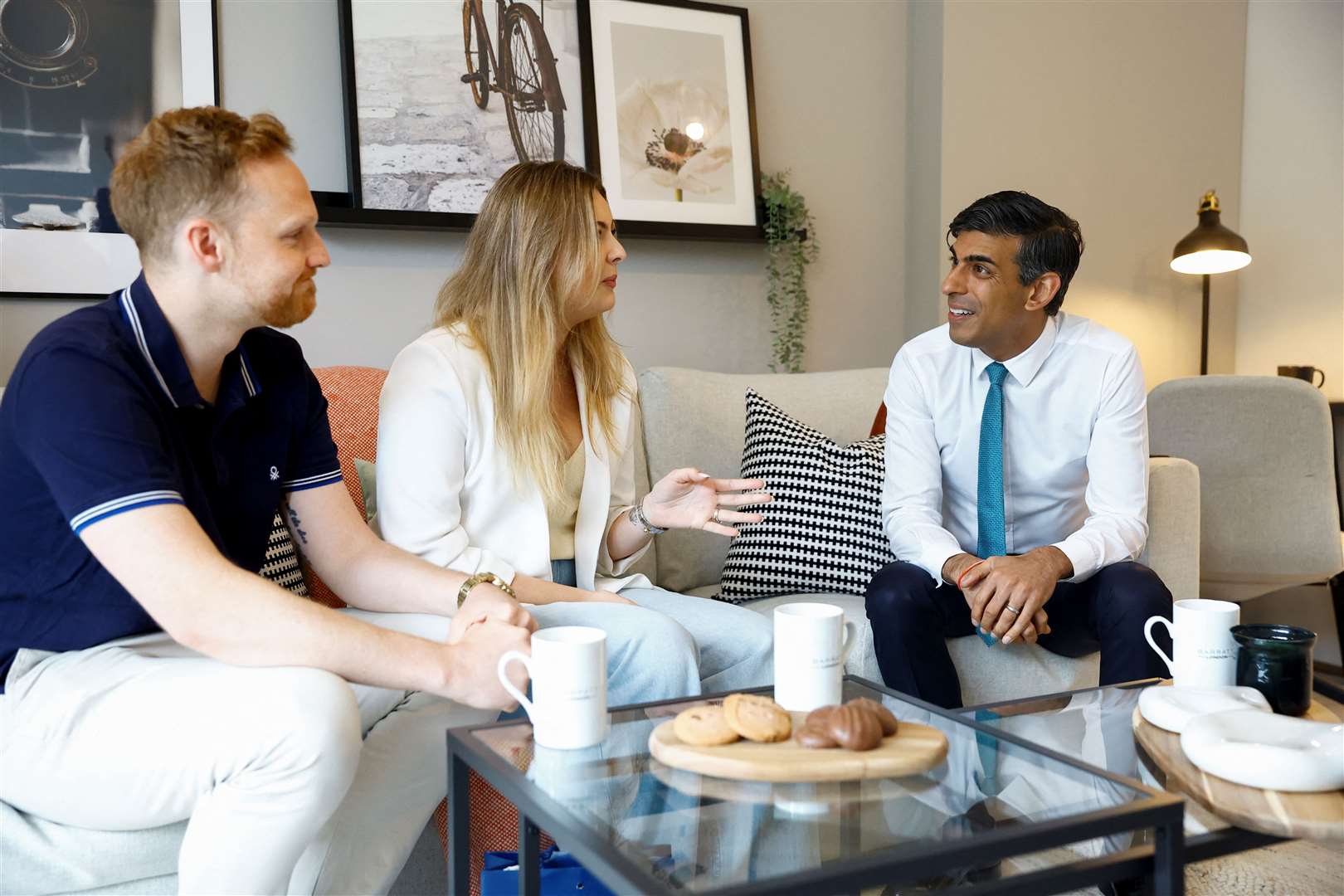 Prime Minister Rishi Sunak speaks to new homeowners Victoria and Ryan Adair during a visit to Hayes Village (Pete Cziborra/PA)