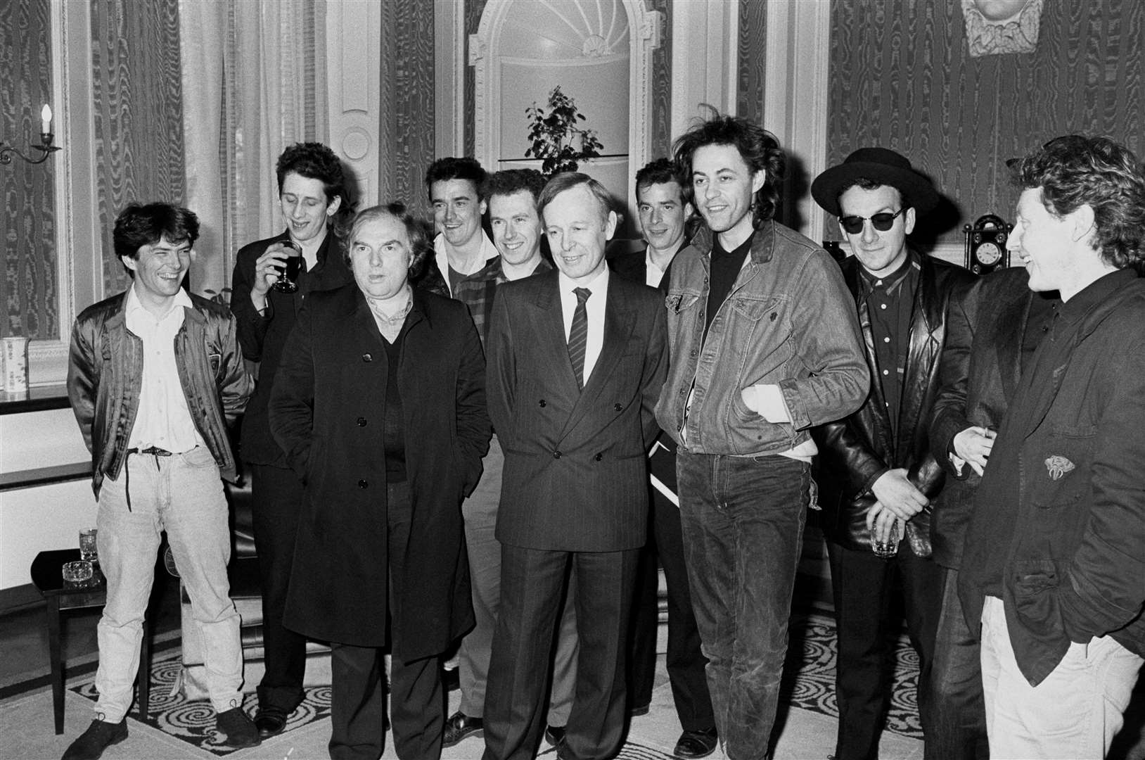 Pop stars fronted by Bob Geldof, at the Irish Embassy in London with Ambassador Noel Dorr. From left: Pete Briquette (Boomtown Rats), Shane MacGowan (The Pogues), Van Morrison, Spider Stacey, Jem Finer (both Pogues), Noel Dorr, James Fearnley (The Pogues), Bob Geldof, Elvis Costello, Cait O’Riordan (Pogues, hidden) and Paul Brady (PA)
