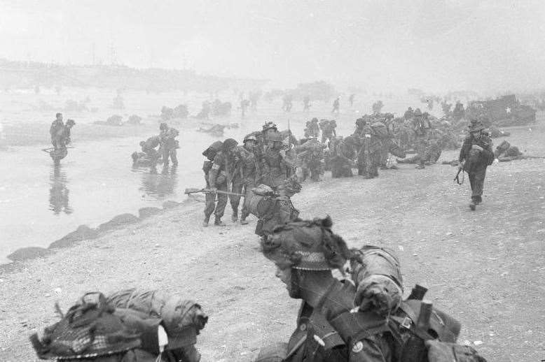 Troops of 3rd Infantry Division on Queen Red beach, Sword area, around 8.45am, on D-Day. In the foreground are sappers of 84 Field Company Royal Engineers, part of No5 Beach Group, identified by the white bands around their helmets. Behind them, medical orderlies of 8 Field Ambulance, RAMC, can be seen assisting wounded men. In the background commandos of 1st Special Service Brigade can be seen. Picture: http://www.iwm.org.uk/collections/item/object/205193046